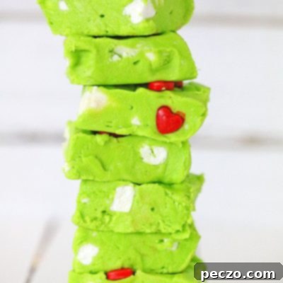 Slices of Grinch fudge displayed in a stack on a wooden table