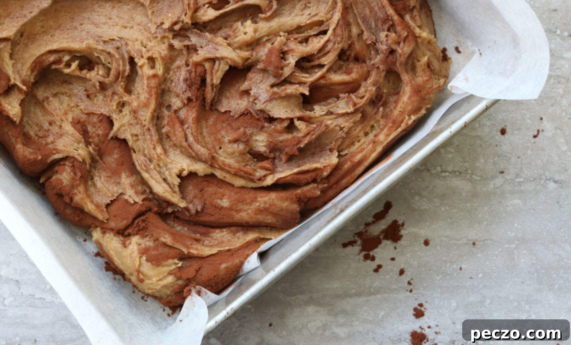 Unbaked Dirty Blondie batter showing cocoa swirls before baking