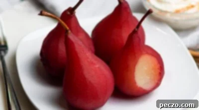 Close up image of wine poached pears on a white serving plate