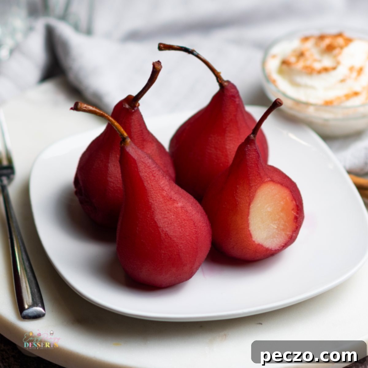 Close up image of wine poached pears on a white serving plate