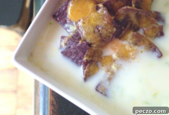 Delicious creamy corn soup garnished with fresh herbs in a rustic bowl