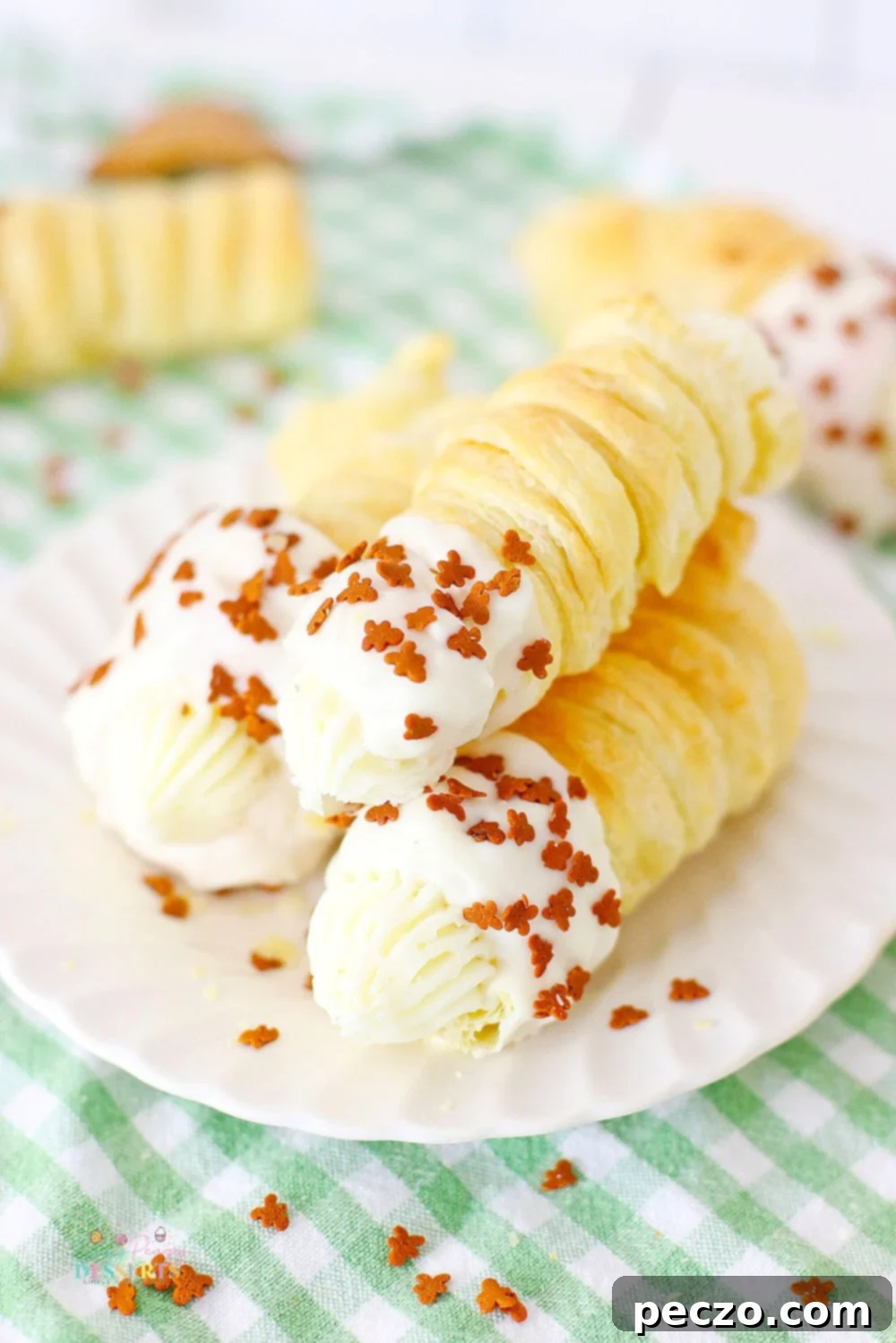 Three beautifully decorated gingerbread cream horns on a white plate, ready to be served for a festive occasion.
