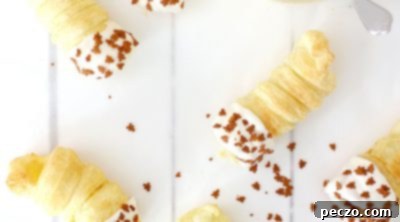 A filled cream horn being placed on parchment paper.