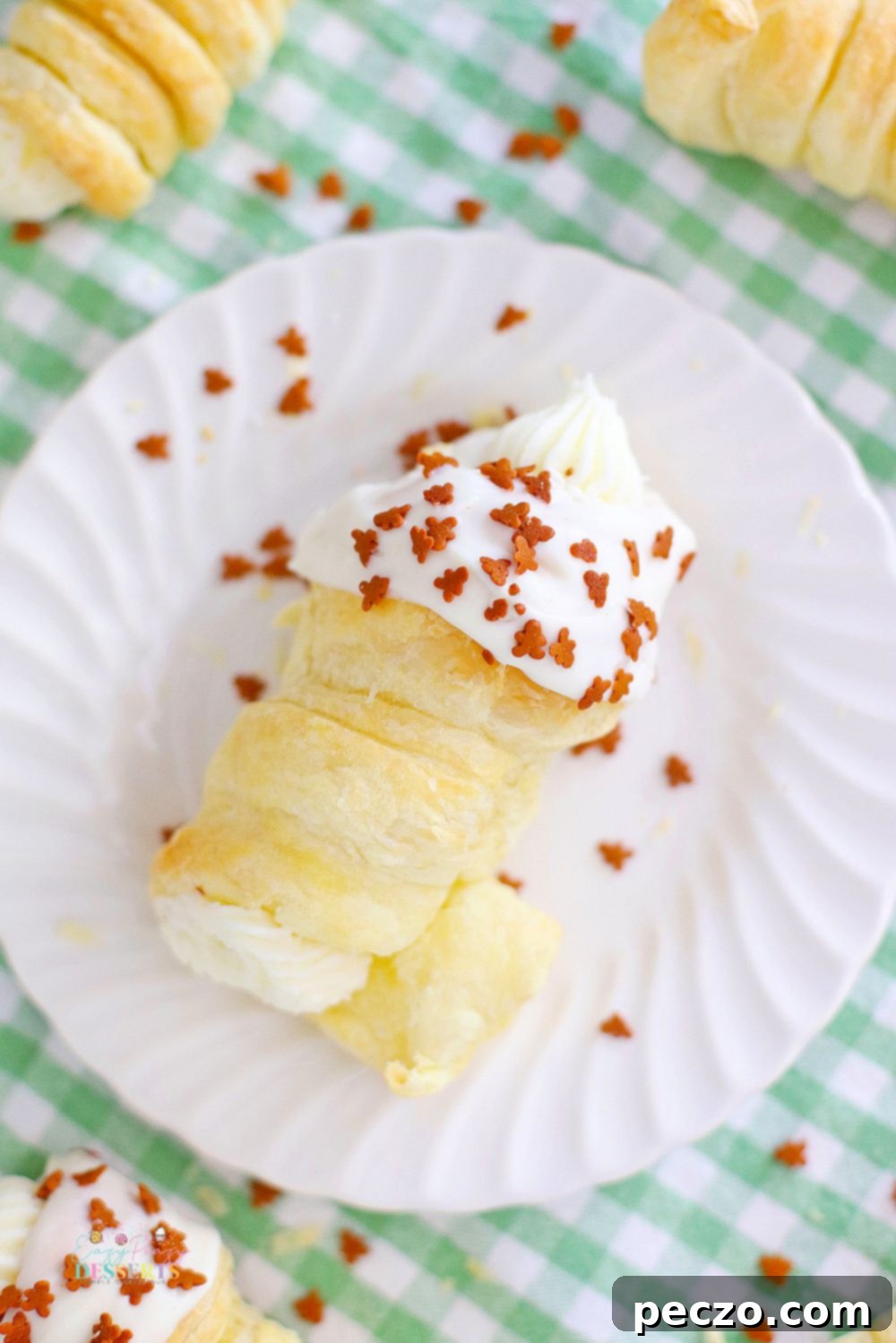 A close-up view of a baked cream horn, rich in gingerbread flavor, with a generous amount of cream filling peeking out from both ends.