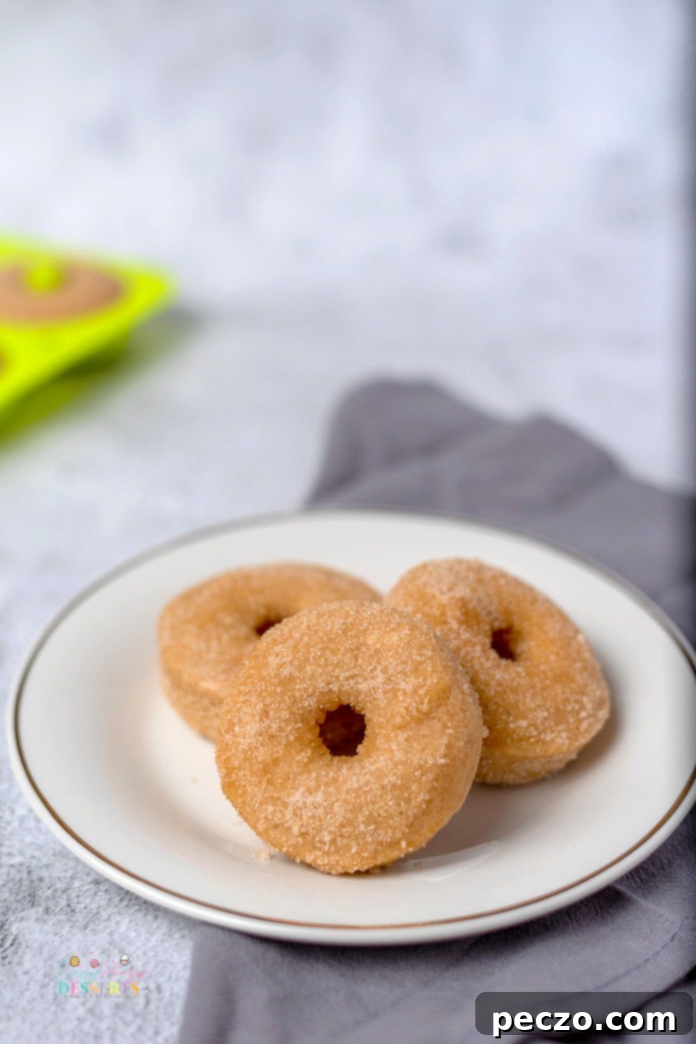 Image of three baked cinnamon donuts on a plate