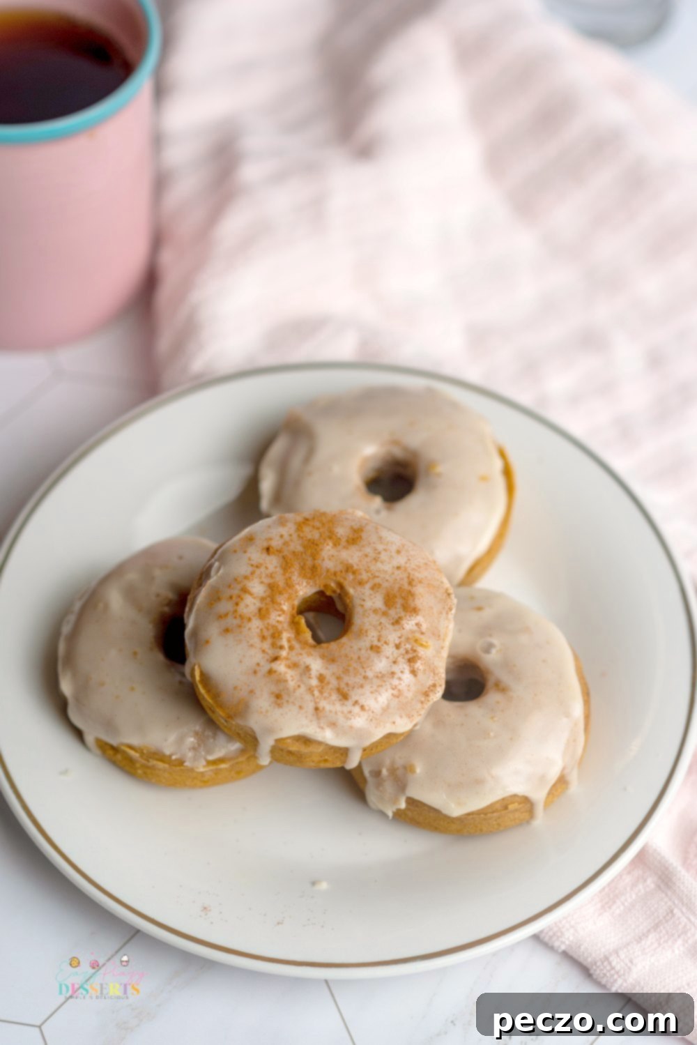 Overhead image of beautifully arranged vegan pumpkin donuts with a rich maple syrup glaze, showcasing their inviting texture.