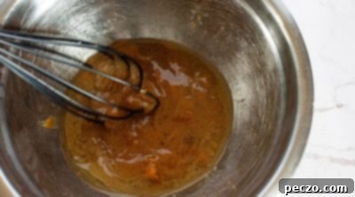 Mixing wet ingredients for vegan pumpkin donuts in a separate bowl.