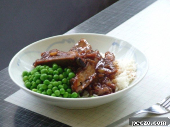 Mouthwatering Sticky Ginger Soy Ribs served with rice and green peas