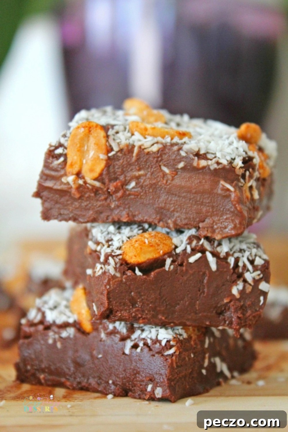 Three perfectly cut squares of 2-ingredient chocolate fudge, showcasing their rich, dark brown color and smooth texture, inviting a taste