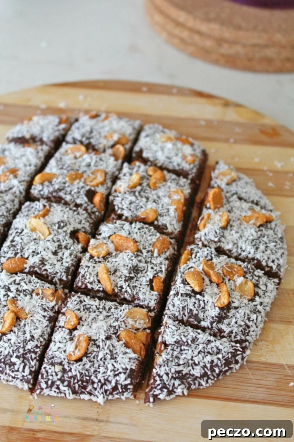 A close-up of homemade microwave fudge, generously garnished with shredded coconut and crunchy peanuts, highlighting its inviting texture and delicious additions