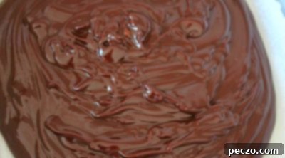 Fudge mixture being poured into a wax paper lined baking dish, ready to set