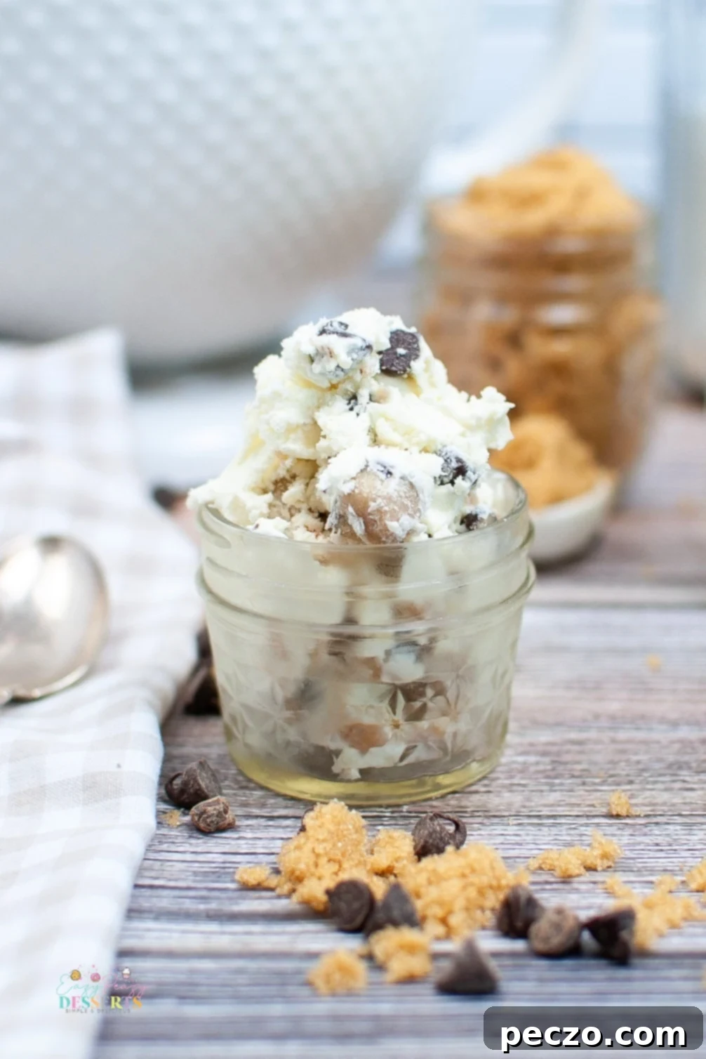 Couple of scoops of chocolate chip cookie dough ice cream in a jar, garnished with a spoon