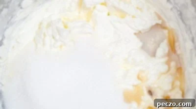 Whisking heavy cream until soft peaks form
