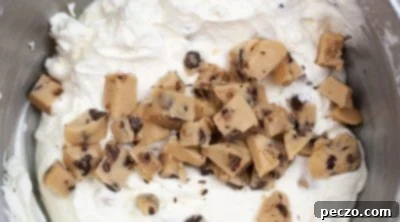 Folding cookie dough bites, sugar, and vanilla into whipped cream