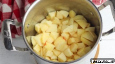 Apples cooking in a saucepan for pie filling