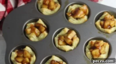 Mini apple pies filled with apple mixture and topped with pecans