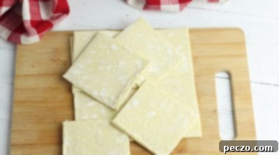 Puff pastry squares being cut for mini apple pies