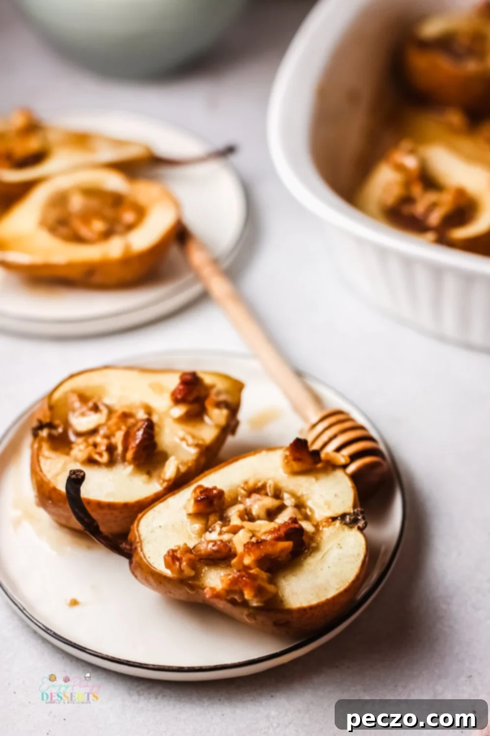 Cinnamon baked pears in a dessert plate, with a spoon.