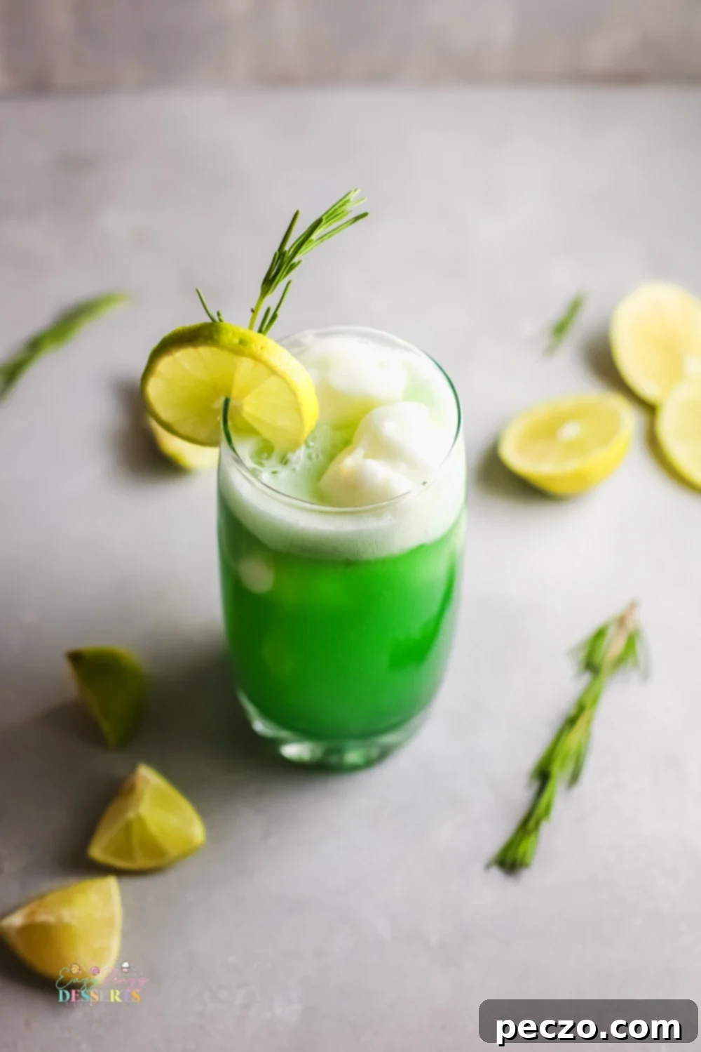 A close-up of a green sherbet punch in a clear drinking glass, with condensation on the outside.