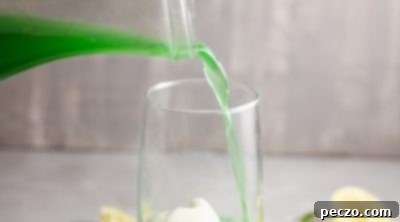 Assembling the punch: adding simple syrup to sherbet in a glass.