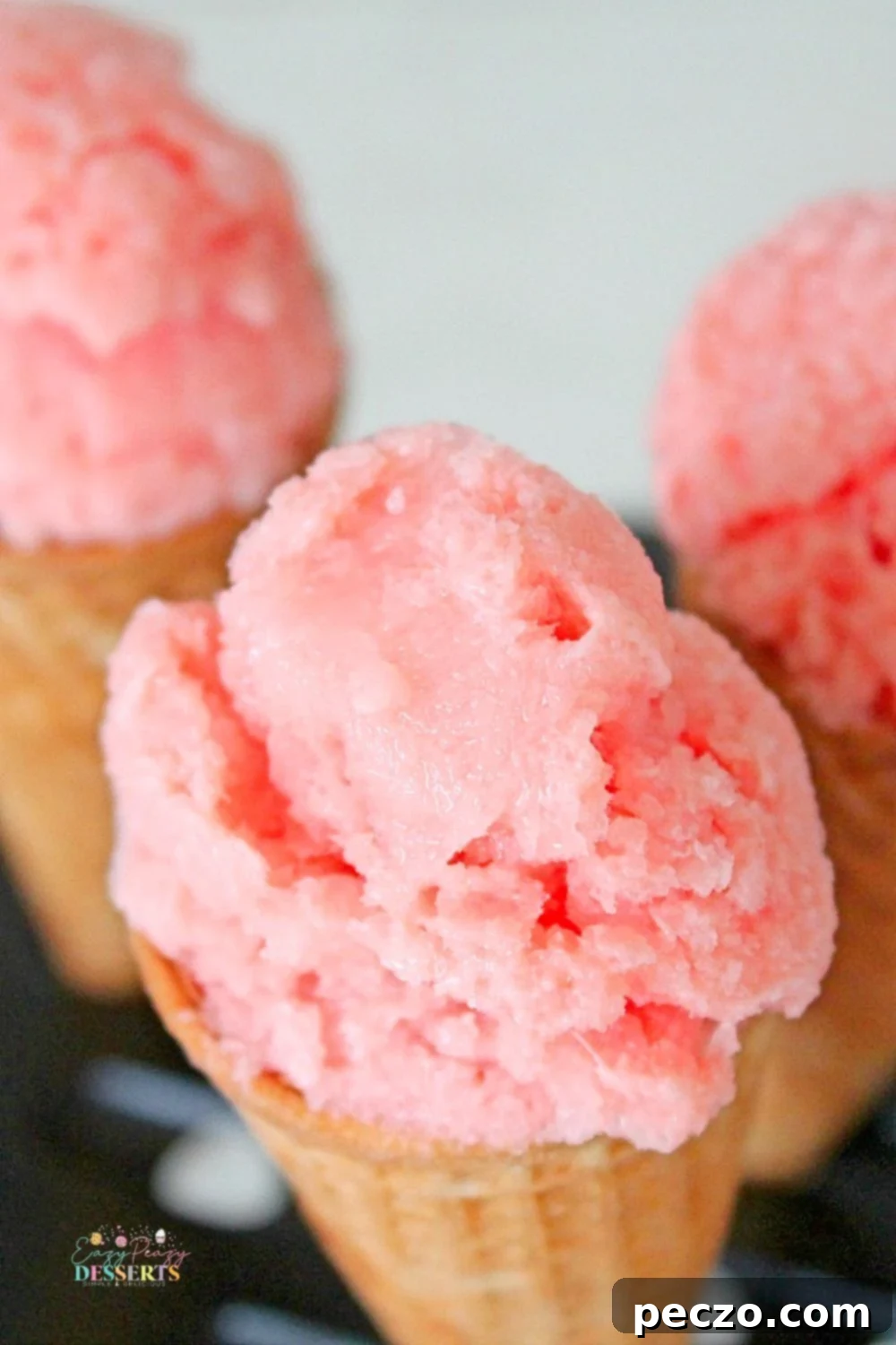Watermelon ice cream recipe in ice cream cones, garnished with fresh mint leaves