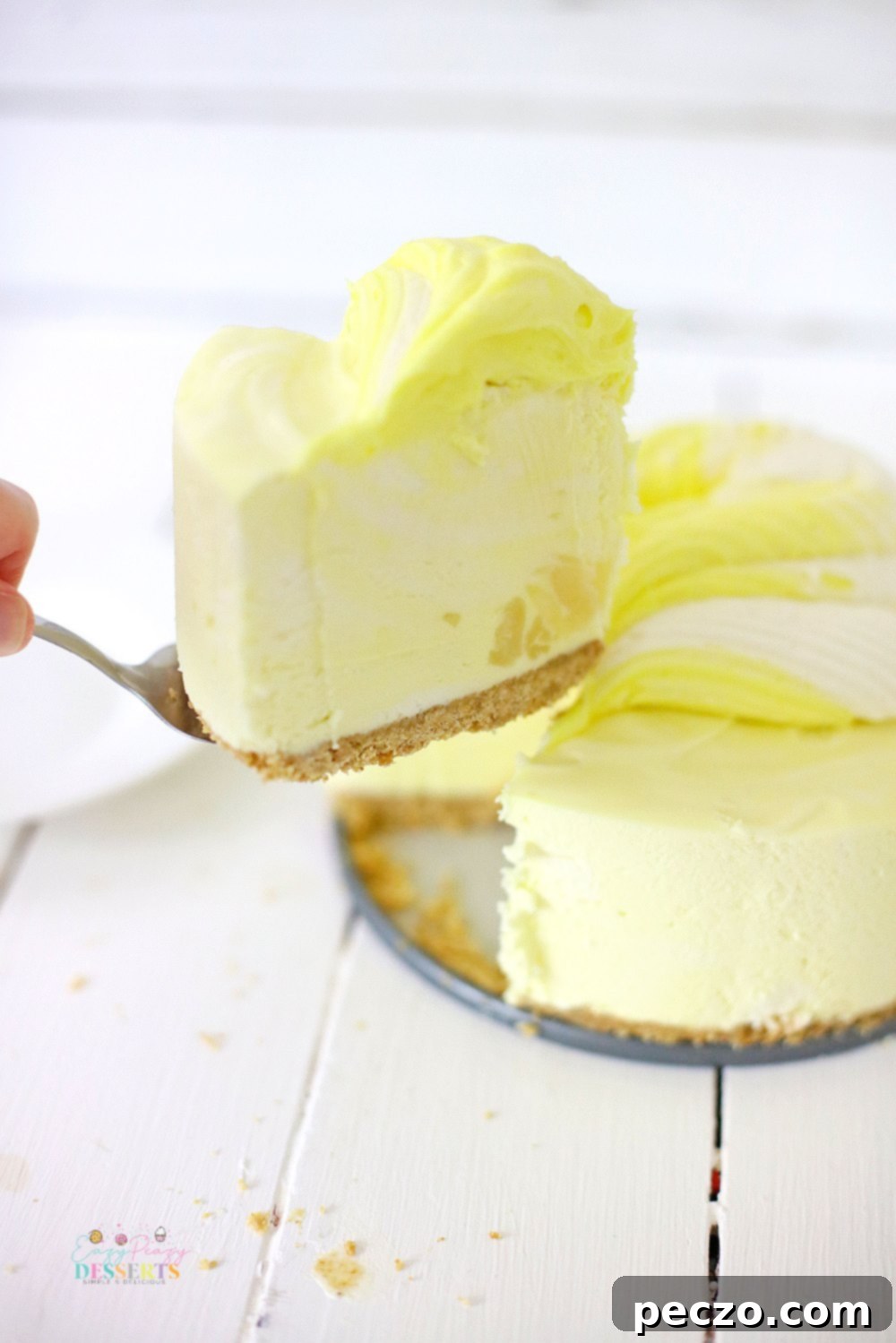 A delectable slice of no-bake pineapple cheesecake on a white plate, highlighting its creamy texture and golden crust.