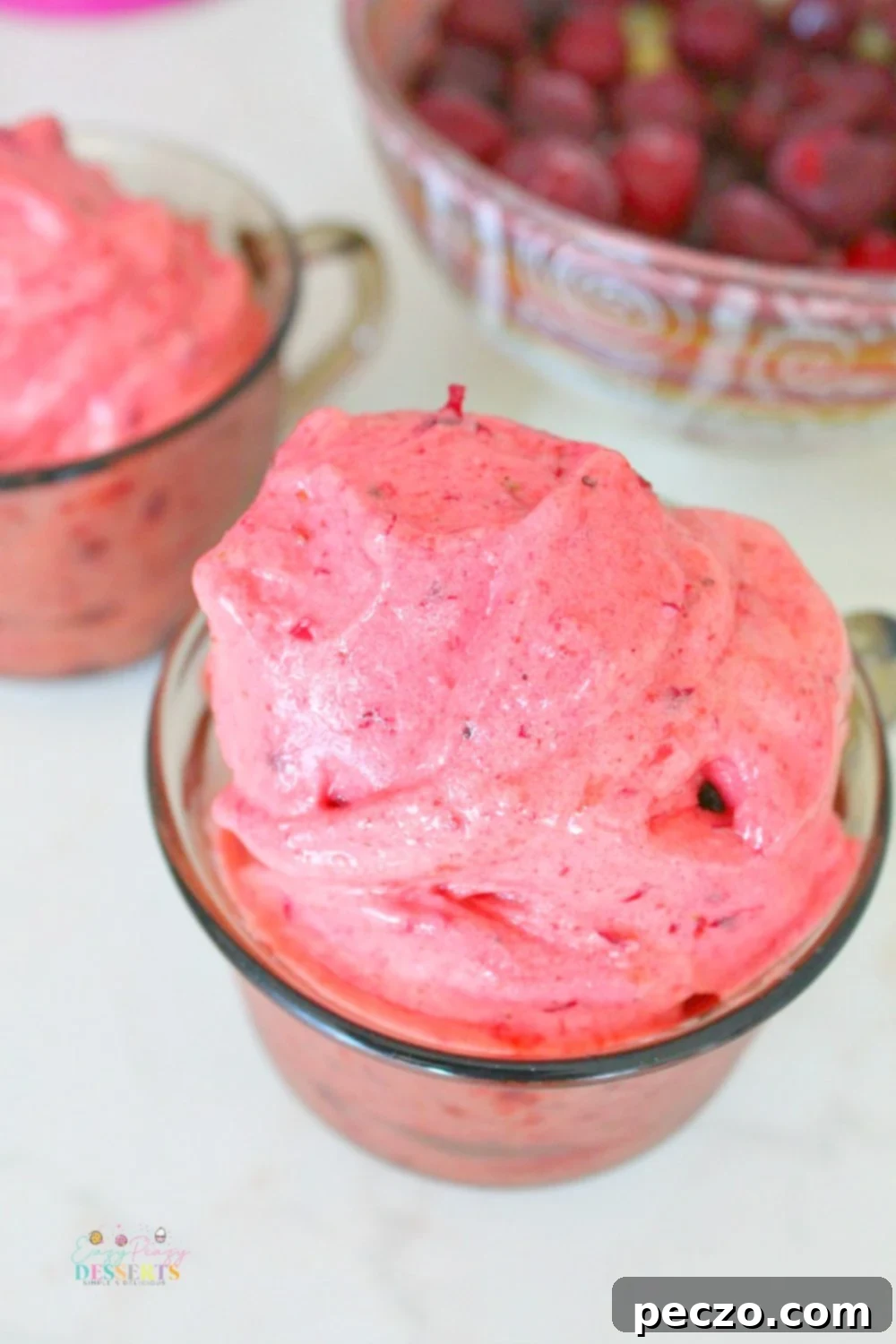 Overhead image of colorful frozen fruit ice cream in bowls, garnished with fresh fruit