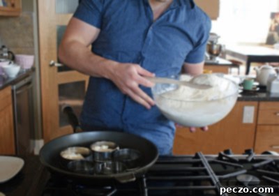 Pierre's Signature Crumpets 2 Pierre carefully pouring crumpet batter into rings on a hot skillet