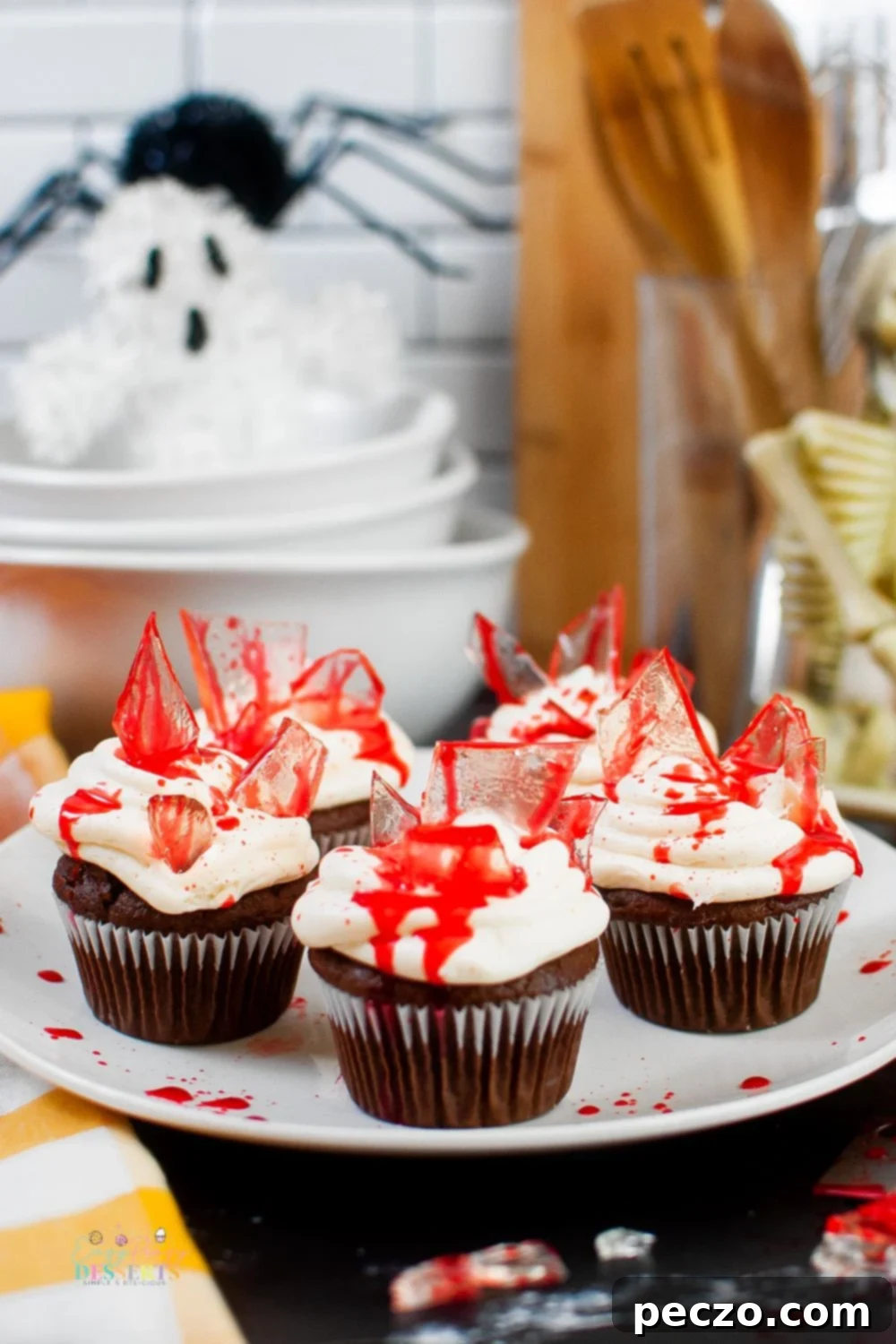 Close up image of bloody Halloween cupcakes on a serving plate, showcasing the sugar glass and red 'blood' details.