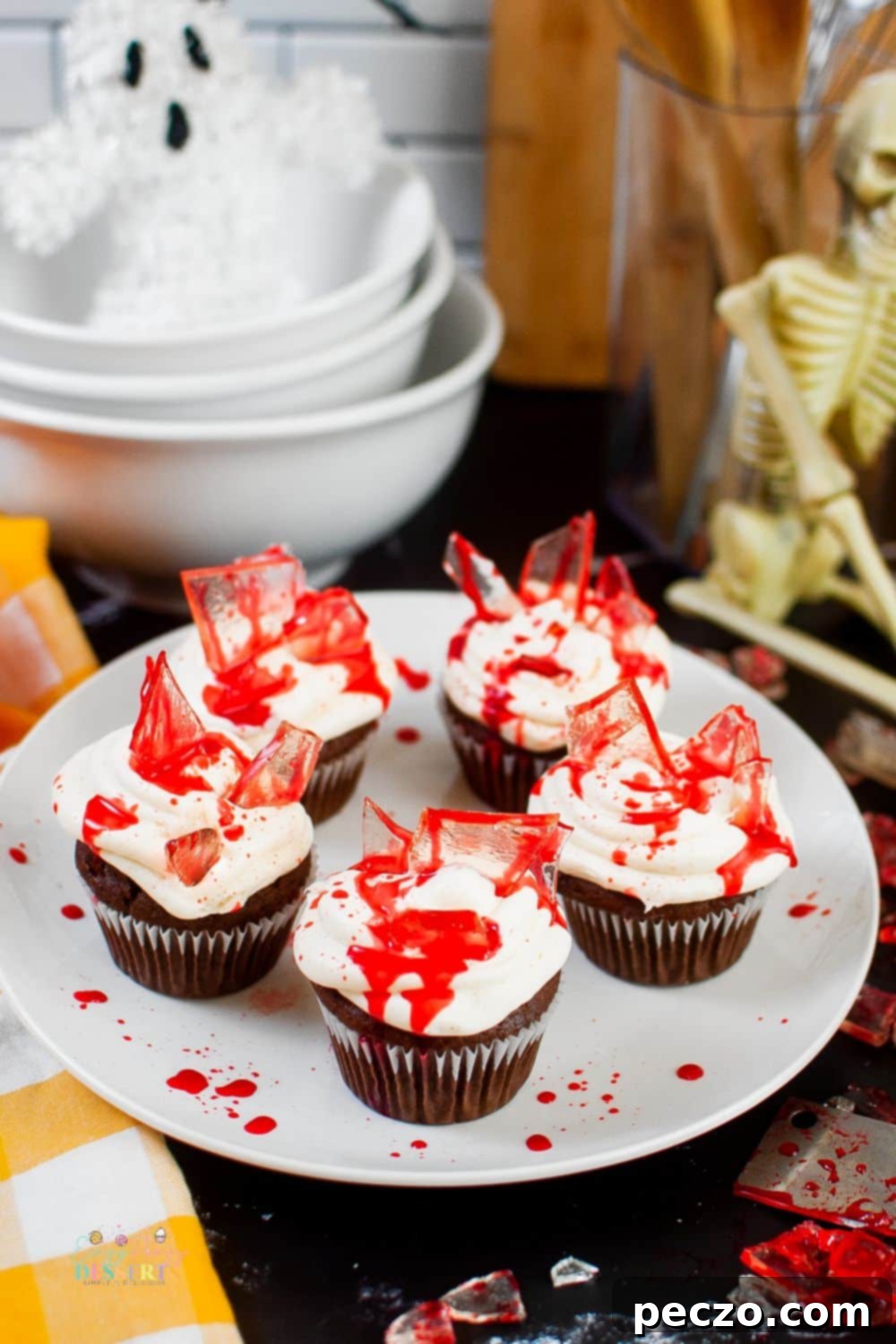 Bloody glass cupcakes for Halloween displayed on a dark background, showing various angles of the decorations.