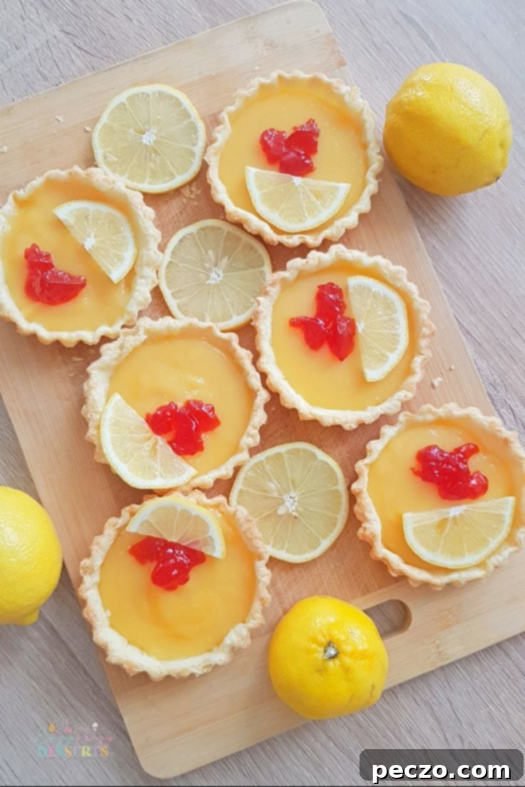 Close-up of Individual Lemon Tarts, highlighting the golden brown pastry and smooth lemon filling