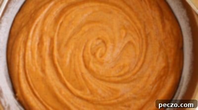 Pouring pumpkin cake batter into an air fryer pan
