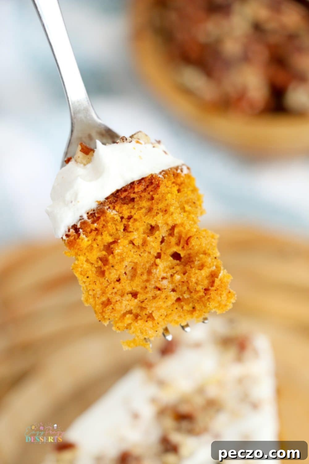 A small bite of moist pumpkin cake made in an air fryer, topped with cream