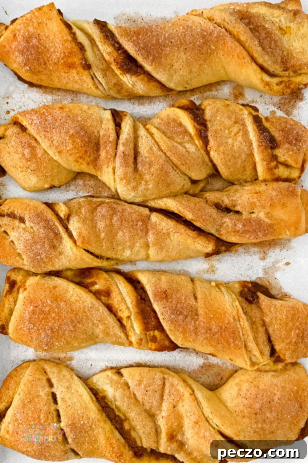 Pumpkin strip pastries arranged neatly on a baking sheet, ready for the oven.