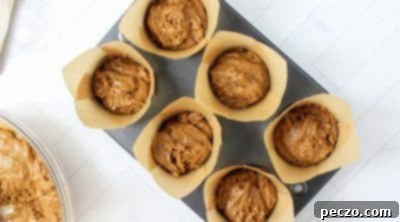 Gingerbread muffin batter in tin with streusel sprinkled on top