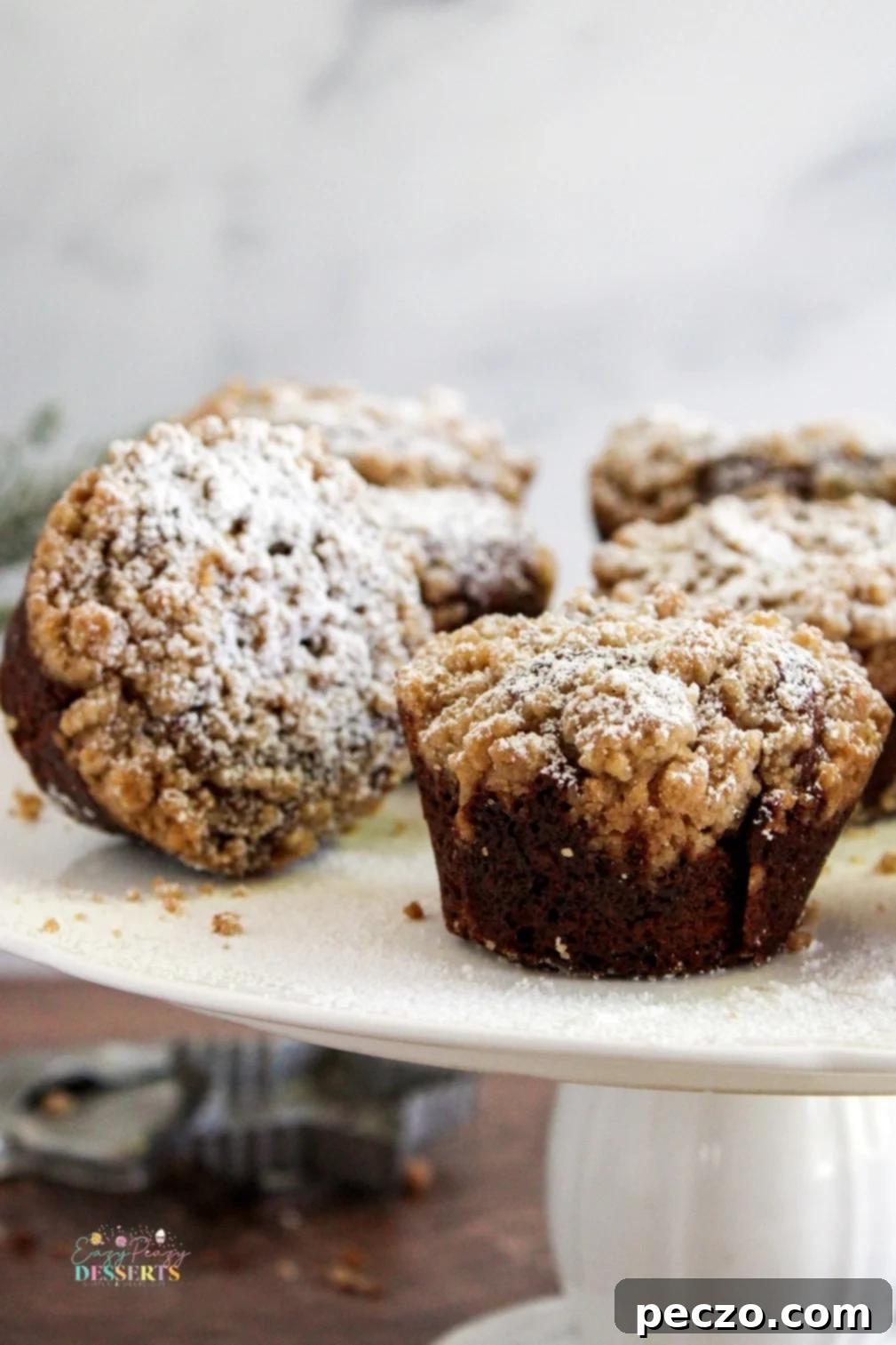 Close-up of baked gingerbread streusel muffins, highlighting the dark, rich color from molasses and golden streusel