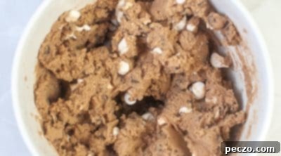 Folding chocolate chips and mini marshmallows into cookie dough