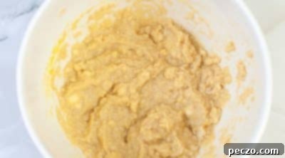 Mixing eggs and vanilla into wet ingredients for hot cocoa cookies