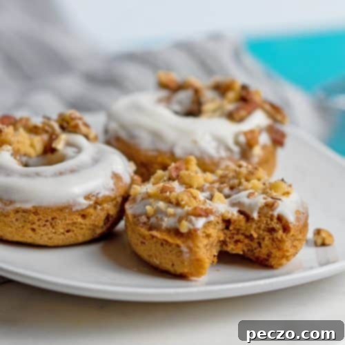 Baked cake donuts with frosting and chopped nuts