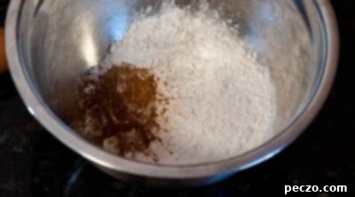 Dry ingredients for carrot cake donuts being whisked in a bowl.