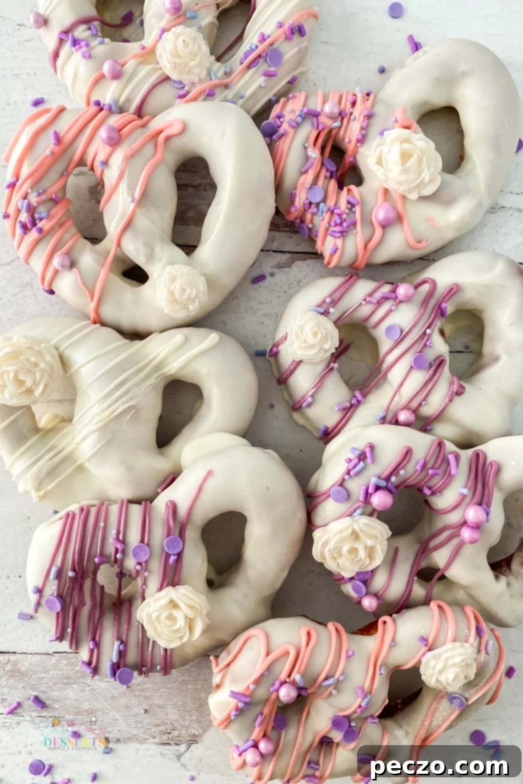 White chocolate covered pretzels with pink and purple decorations