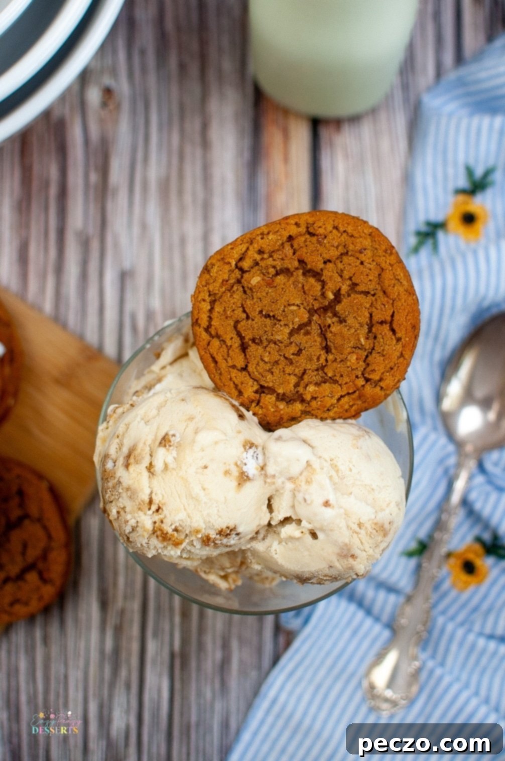 Four scoops of oatmeal cream pie ice cream in varying sizes, presented in different ice cream bowls, highlighting the creamy texture and cookie pieces.