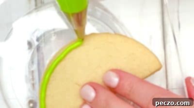 Piping lime green and dark green frosting for watermelon rind