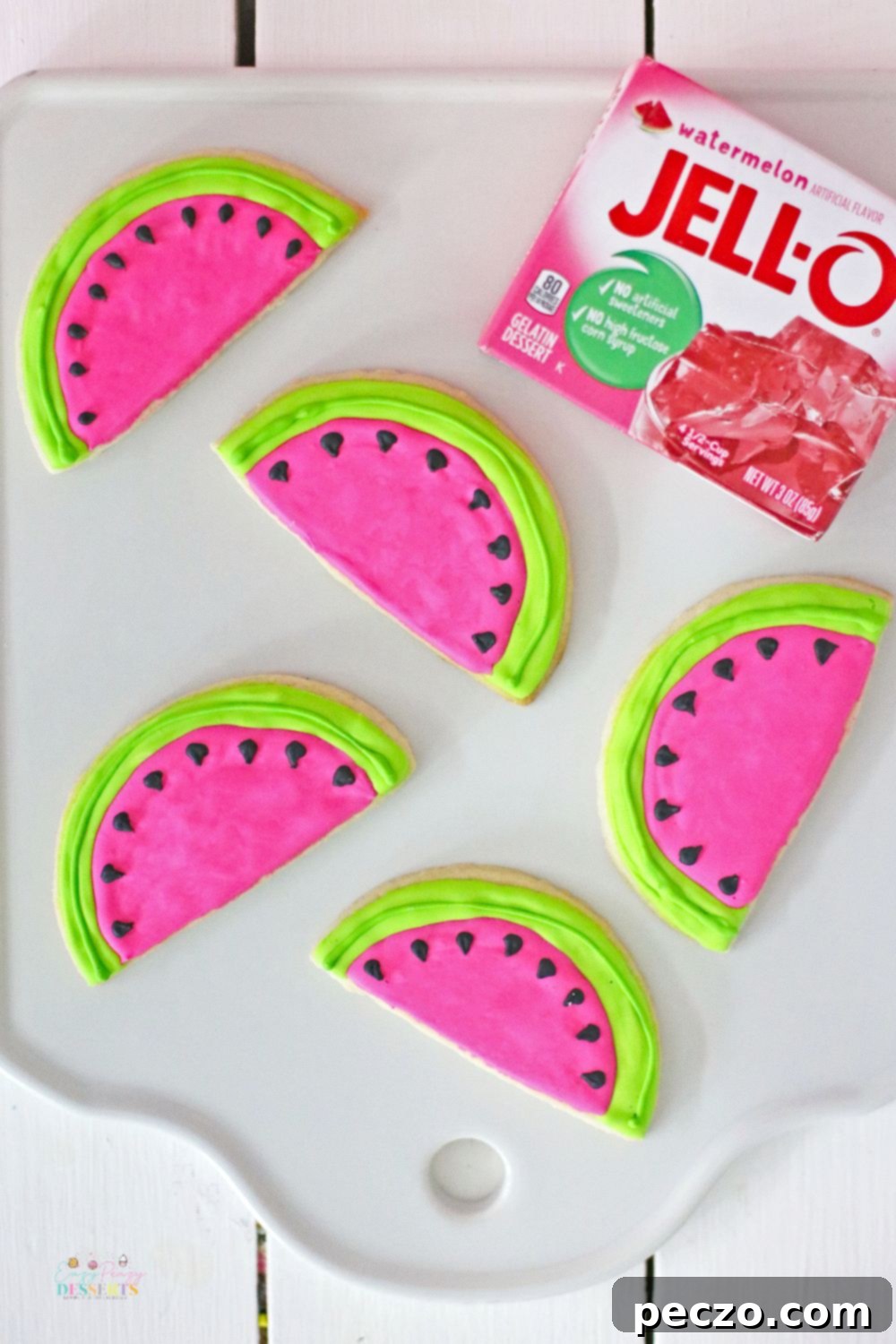 Watermelon shaped cookies decorated with green, pink, and black frosting