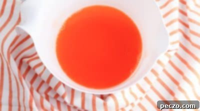 Dissolving orange gelatin in boiling water for orange fluff salad