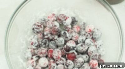 Tossing cranberries in flour