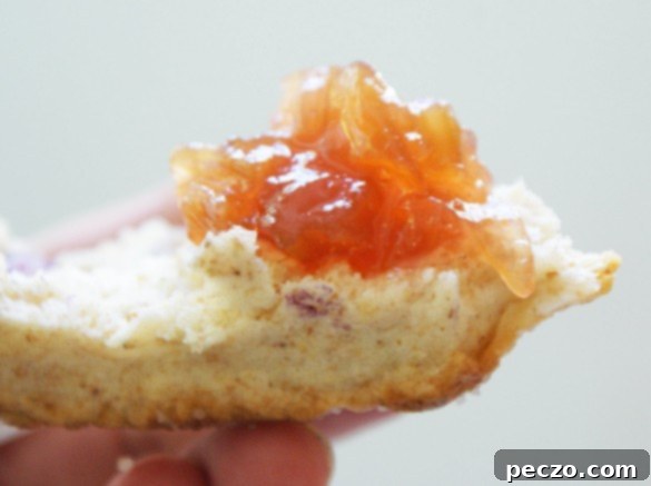 Close-up of vibrant rhubarb ginger jam in a jar, perfect for toast and scones.