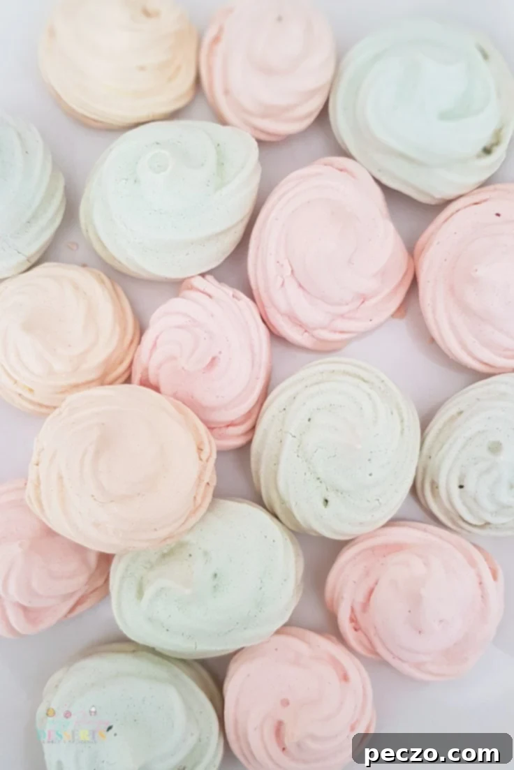 A selection of baked mini meringues in assorted pastel colors, beautifully arranged and showcasing their airy, crunchy texture.