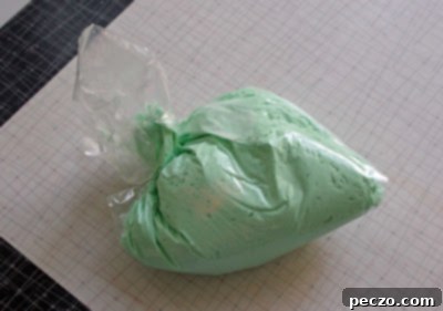 Dragon cake base before decorative elements are added, showing the smooth green icing