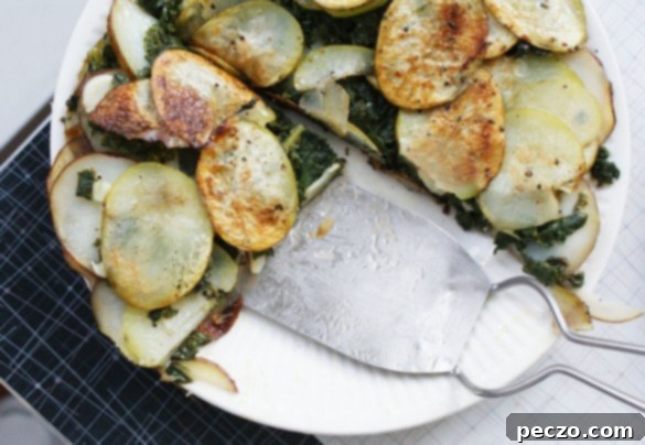 Sliced potato and kale galette with a rustic golden crust, ready to be served.